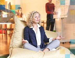 A woman meditating at work reducing stress and increasing her vitality